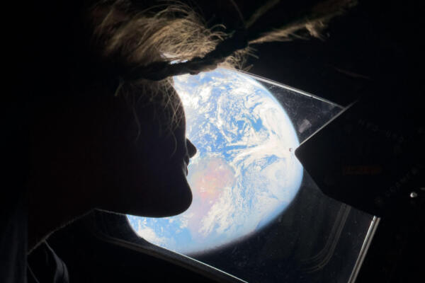 Esta imagen distribuida por la NASA y tomada por un miembro de la tripulación de Artemis II muestra a la especialista de misión Christina Koch observando la Tierra a través de la ventana de la nave espacial Orion el 2 de abril de 2026.