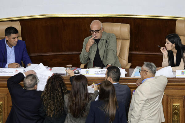 El presidente de la Asamblea Nacional de Venezuela, Jorge Rodríguez (C), flanqueado por el primer vicepresidente Pedro Infante (I) y la segunda vicepresidenta América Pérez, conversa con los diputados durante una sesión de la Asamblea Nacional en Caracas el 7 de abril de 2026. (Foto de Jesús Vargas / AFP)
