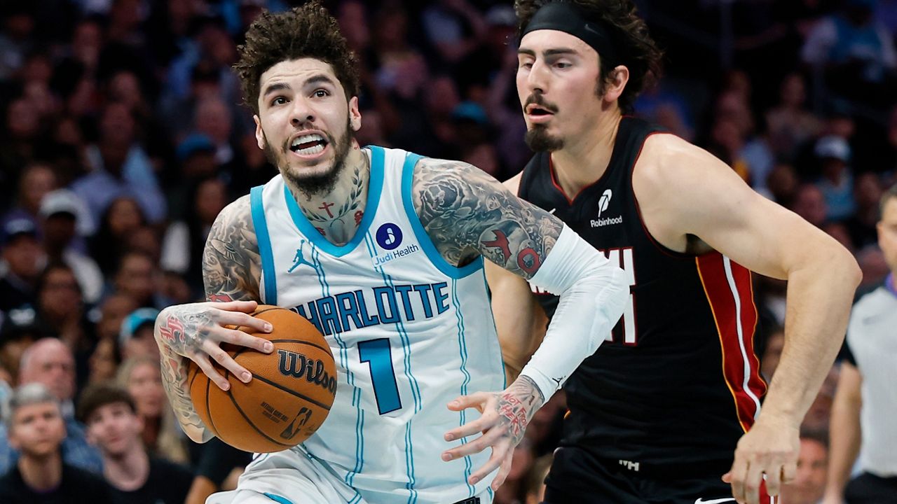 Lamelo Ball, de Charlotte Hornets, ataca ante la marca de Jaime Jaquez Jr. de Miami Heat en juego Play-In de la NBA