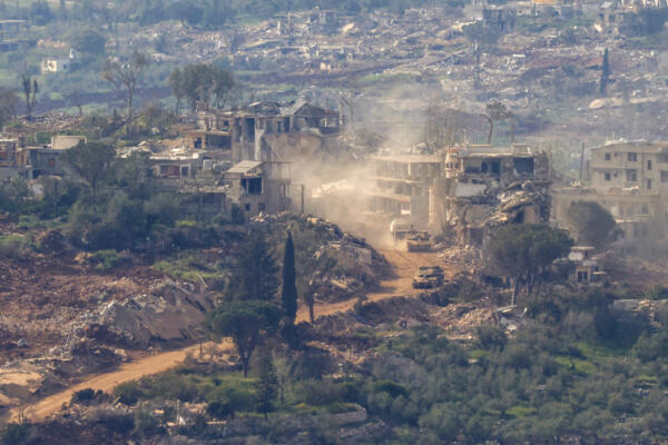Esta fotografía, tomada desde el norte de Israel, muestra tanques y vehículos militares israelíes circulando por una carretera entre casas destruidas en el sur del Líbano, cerca de la frontera con Israel, el 25 de abril de 2026. El Ministerio de Salud libanés informó que los ataques israelíes del 25 de abril en el sur del país causaron la muerte de cuatro personas, a pesar del alto el fuego que se extendió esta semana en la guerra entre Israel y el grupo militante Hezbolá. (Foto de Jalaa MAREY / AFP)
