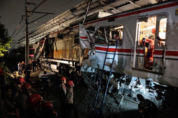 Agentes de seguridad inspeccionan el lugar de una colisión ferroviaria mientras los rescatistas trabajan para salvar a cinco sobrevivientes atrapados dentro de un vagón después de que la locomotora de un tren de pasajeros atravesara el vagón trasero de un tren de cercanías en la estación Bekasi Timur en Bekasi, Java Occidental, el 28 de abril de 2026. (Foto de Yasuyoshi Chiba / AFP)