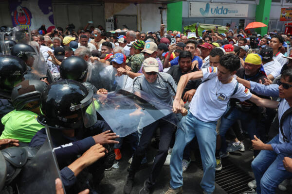 Personas se enfrentan con integrantes del Cuerpo de Policía Nacional Bolivariana (CPNB) durante una manifestación de organizaciones sindicales, estudiantiles y gremiales que exigen aumentos salariales este jueves, en Caracas (Venezuela). EFE/ Miguel Gutiérrez