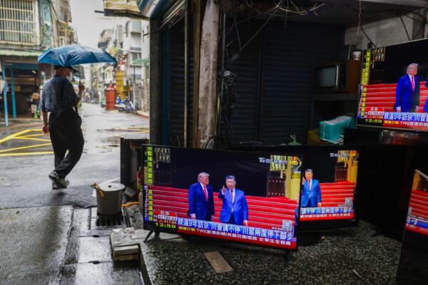 TAIPEI (Taiwán), 14/05/2026.- Un peatón pasa junto a una tienda de segunda mano y reparación de televisores, con pantallas que transmiten la reunión en Pekín entre el presidente estadounidense, Donald Trump, y el chino, Xi Jinping, en Taipéi, Taiwán, el 14 de mayo de 2026. 
EFE/EPA/RITCHIE B. TONGO