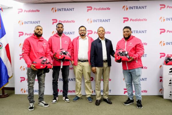 El director ejecutivo del Intrant, Milton Morrison y el director de Operaciones de PedidosYa, Eduardo Castillo entregan cascos a repartidores.