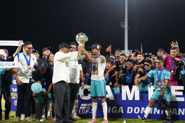 Milton Ray Guevara, presidente de la LDF, entrega el trofeo de campeón al capitán de Salcedo FC, Carlos Rossell.