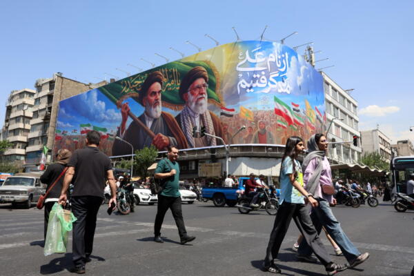Ciudadanos iraníes pasan junto a una gran valla publicitaria con la imagen del difunto líder supremo iraní, el ayatolá Ruhollah Khomeini, y del líder supremo, el ayatolá Ali Khamenei, en una calle de Teherán, Irán, este miércoles. FOTO: EFFE