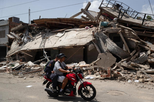 Personas transitan frente a edificios afectados por terremotos este jueves, en Catia La Mar (Venezuela). El presidente del Parlamento de Venezuela, el chavista Jorge Rodríguez, informó que los fallecidos por los dos terremotos ocurridos el miércoles en su país ya dejan 920 muertos y 3.360. EFE/ Ronald Peña R