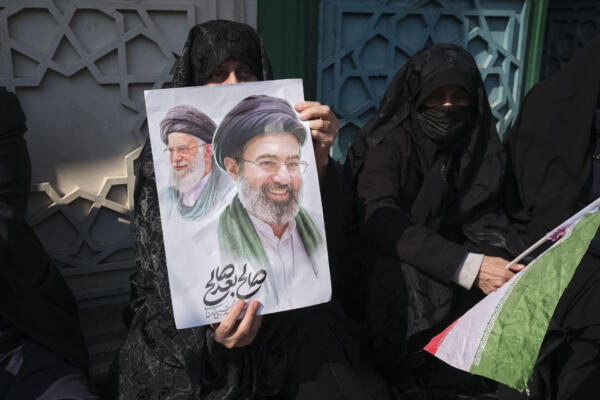 Una mujer porta una pancarta con la imagen del nuevo líder supremo de Irán, Mojtaba Jameneí, y su padre y antecesor en el cargo, Alí Jameneí, durante los funerales Consejo Supremo de Seguridad Nacional, Ali Lariyani, en la plaza Enghelab de Teherán. EFE/Jaime León