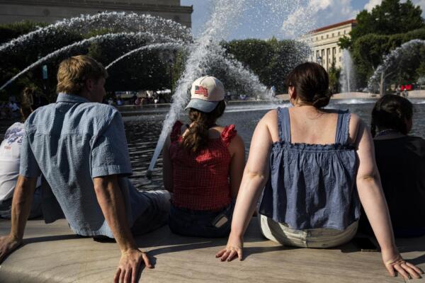Personas se refrescan en la fuente del Jardín de Esculturas de la Galería Nacional de Arte, en el National Mall de Washington, DC (EE.UU.), durante temperaturas de calor extremo. EFE/GRAEME SLOAN
