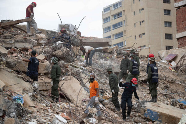 Voluntarios trabajan entre los escombros de edificios colapsados este lunes, en La Guaira (Venezuela). EFE/ Ronald Peña R