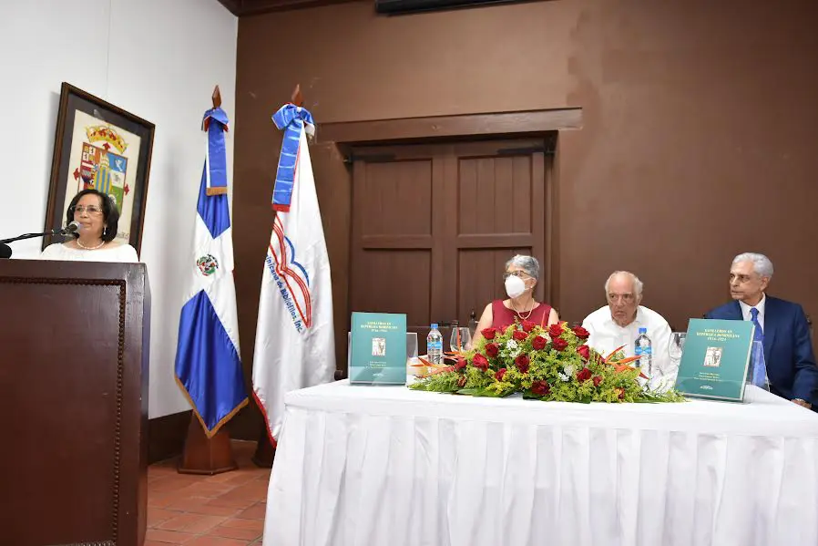 En el pódium, se dirige a los presentes Eleanor Grimaldi Silié, miembro del consejo directivo de la Sociedad Dominicana de Bibliófilos, en la mesa desde la izquierda, María Filomena González Canalda, coautora del libro y Premio Nacional de Literatura; Bernardo Vega y Mariano Mella, directivos de los Bibliófilos.