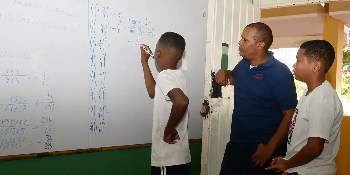 Un estudiante ejecuta una operación algebraica mientras el profesor observa en el Liceo Unión Panamericana, del Ensanche Miraflores, donde ayer más del 95 por ciento de los 400 matriculados volvió a las clases. Félix de la Cruz