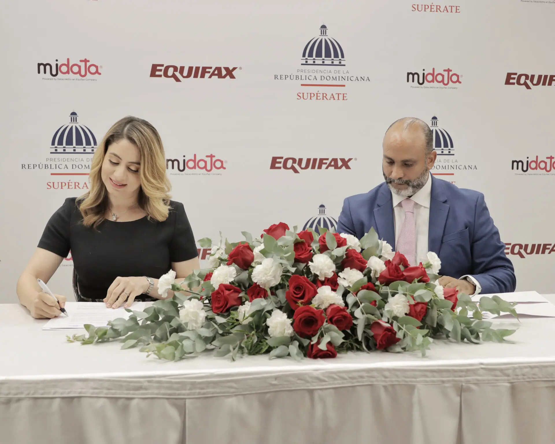 Gloria Reyes, directora general de Supérate, y José Alberto Adam Adam, director general de EquifaxDataCrédito mientras firman el acuerdo. FUENTE EXTERNA