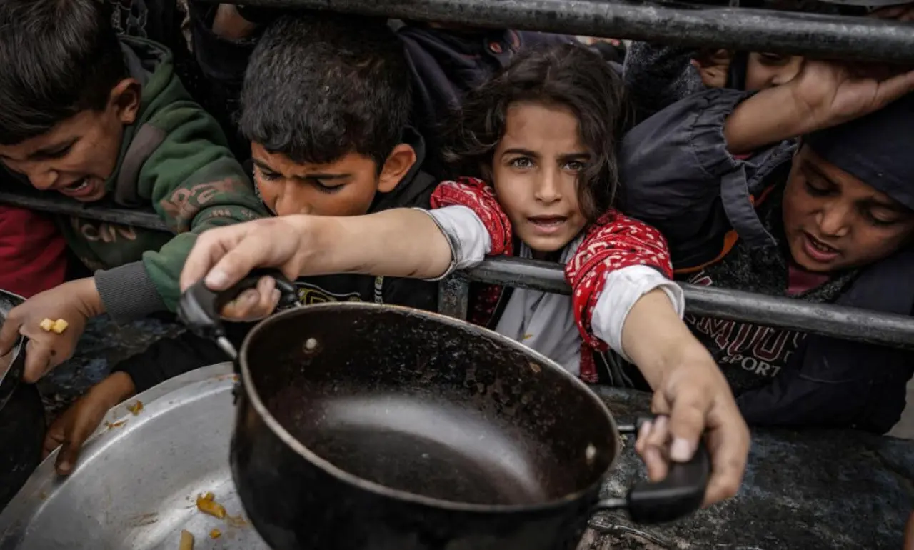 Niños gazatíes esperan el reparto de comida cocinada para los desplazados en el sur de la Franja. Getty Images/Belal Khaled/Anadolu