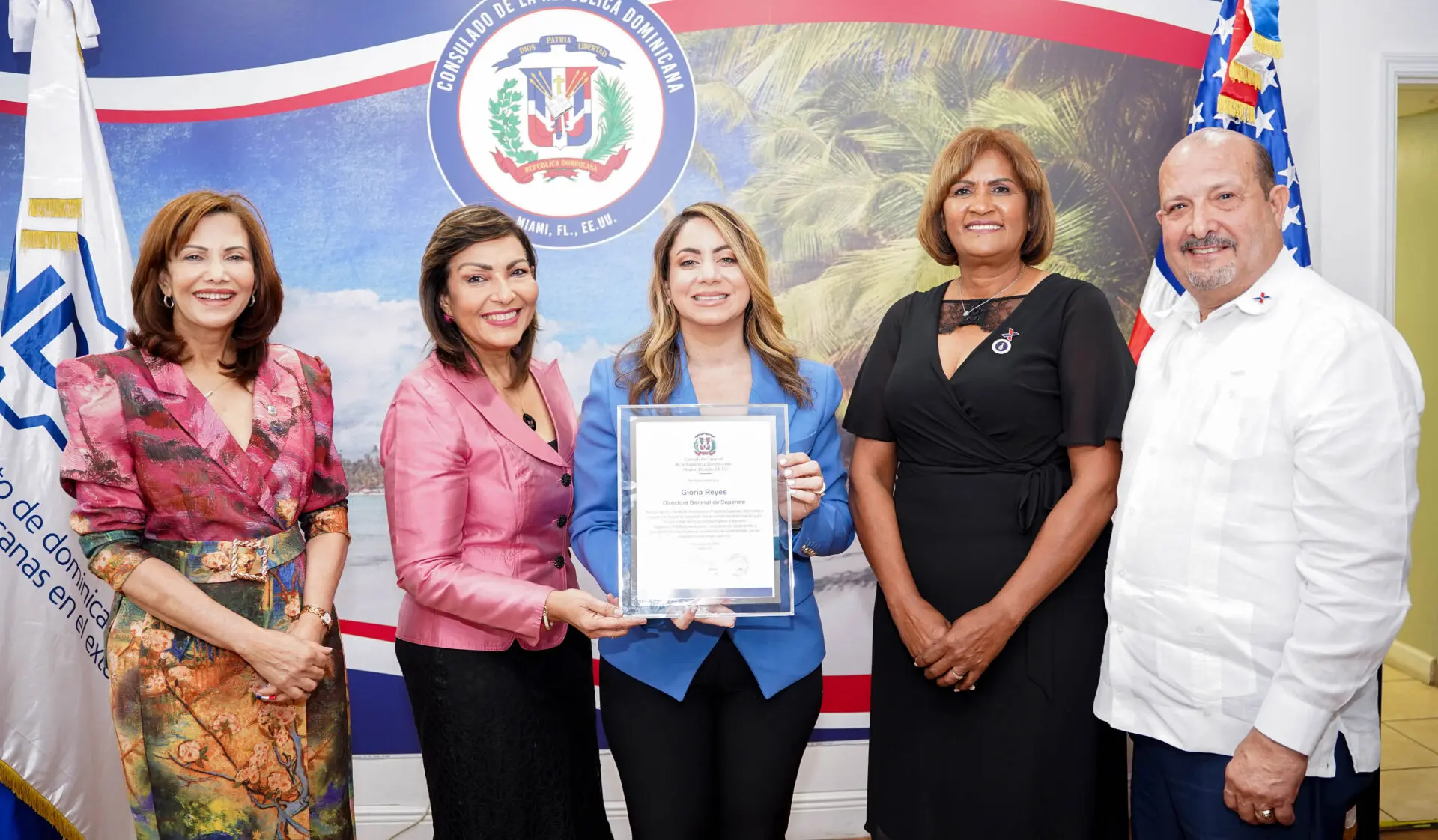 La cónsul de República Dominicana en Miami, Geanilda Vásquez, entrega reconocimiento a la directora general de Supérate, Gloria Reyes. Le acompañan Richard Montilla y Soledad Cruz, funcionarios del Index en Miami, y Adelys Olivares, diputada de Ultramar