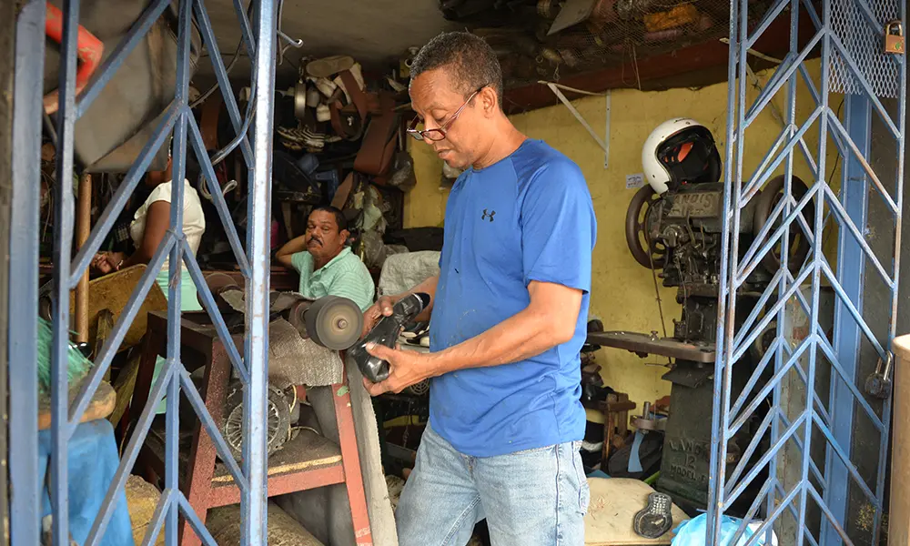 Carlos Grullón, empleado de la Reparadora de Calzados Fé en Dios.