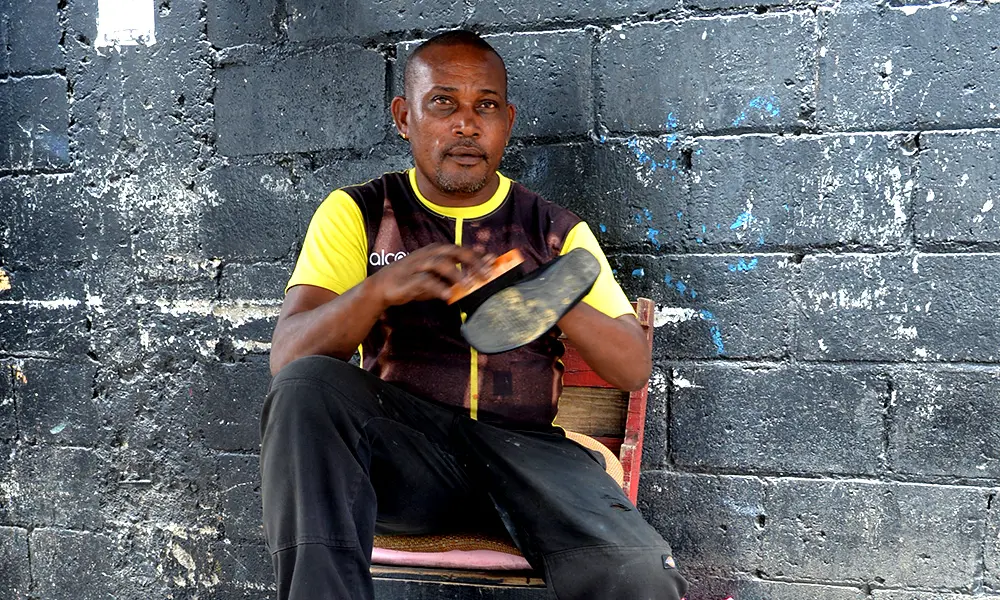 Miguel Rosario mantiene a sus dos hijos limpiando zapatos en la av. Máximo Gómez.