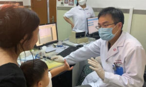 El Dr. Yilai Shu se comunica con un joven paciente en el Hospital Oftalmológico y Otorrinolaringológico de la Universidad de Fudan, en Shanghai (China). Crédito: Hospital Oftalmológico y Otorrinolaringológico de la Universidad de Fudan, Shanghai, China