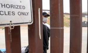 Fotografía de archivo en la que se ve a un migrante mientras espera junto al muro fronterizo en San Ysidro, San Diego (Estados Unidos). EFE/ Manuel Ocaño