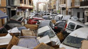 Vehículos amontonados en una calle tras las intensas lluvias de la fuerte dana