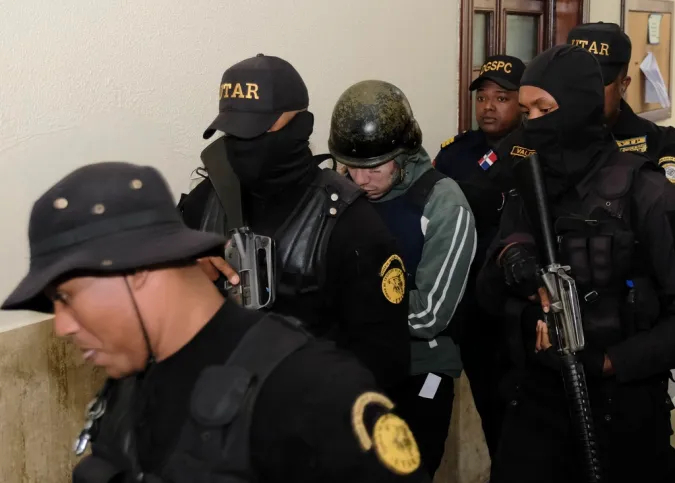 El rapero Daniel Hernández, conocido como Tekashi 6ix9ine, es escoltado por la policía a un área diferente del tribunal, el Palacio de Justicia, en Santo Domingo, República Dominicana, el jueves 25 de enero de 2024