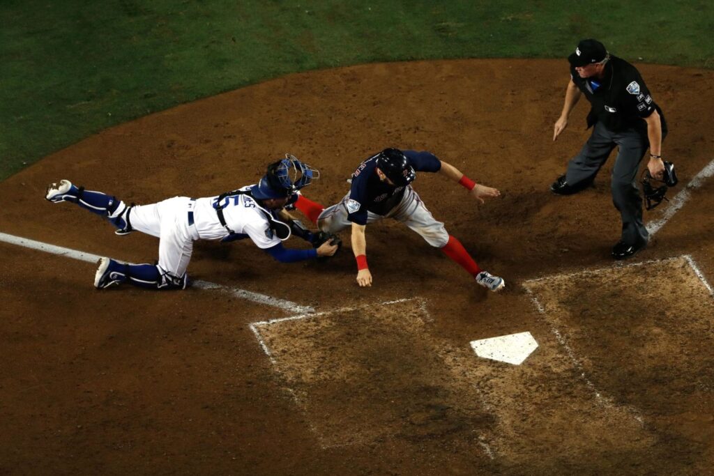 Ian Kinsler, de los Red Sox, fue puesto out en home por Austin Barnes, de los Dodgers, en un tiro de Cody Bellinger durante la décima entrada del Juego 3. Los Dodgers ganaron en la decimoctava entrada de un juego que estableció el récord como el más largo en la historia de la Serie Mundial.