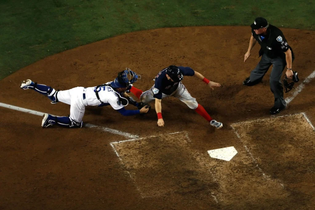 Ian Kinsler, de los Red Sox, fue puesto out en home por Austin Barnes, de los Dodgers, en un tiro de Cody Bellinger durante la décima entrada del Juego 3. Los Dodgers ganaron en la decimoctava entrada de un juego que estableció el récord como el más largo en la historia de la Serie Mundial.