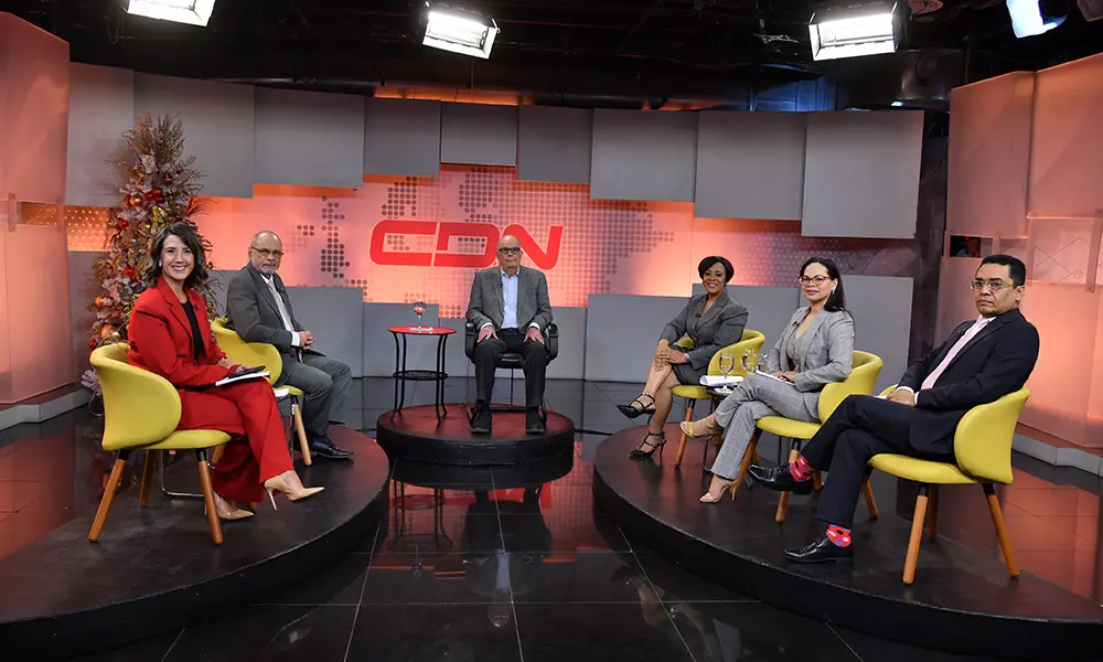 Sonrientes en el set de televisión de CDN, al centro el profesor Cassá.